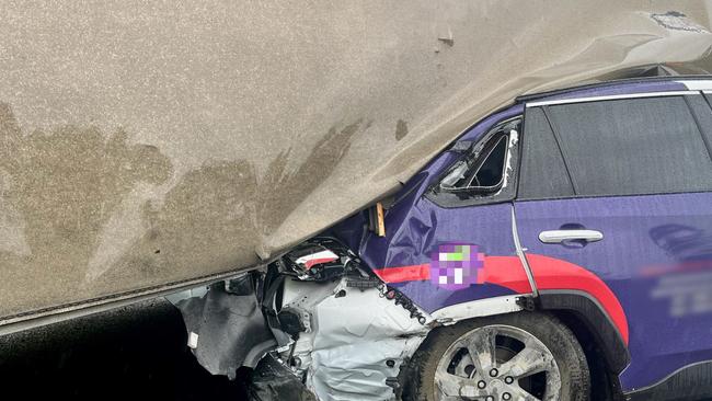 The driver of a car crushed under a truck when it rolled on the Pacific Motorway, was lucky to escape uninjured. Picture: QAS