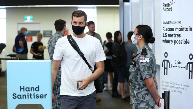 Passengers from Qantas flight QF937 from Brisbane walk from the processing area after being temperature tested and having their G2G pass verified by WA Police on arrival at Perth Airport on November 14. Picture: Getty