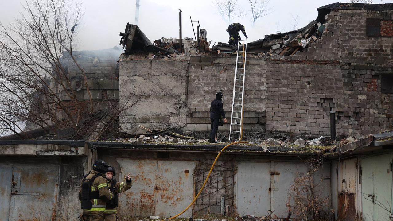 Firefighters survey the damage after a building is gutted by fire following a missile strike in Ukraine. (AFP)