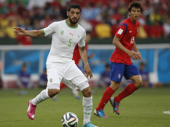 Algerian defender Rafik Halliche controls the ball next to South Korea's forward Koo Ja-Cheol.