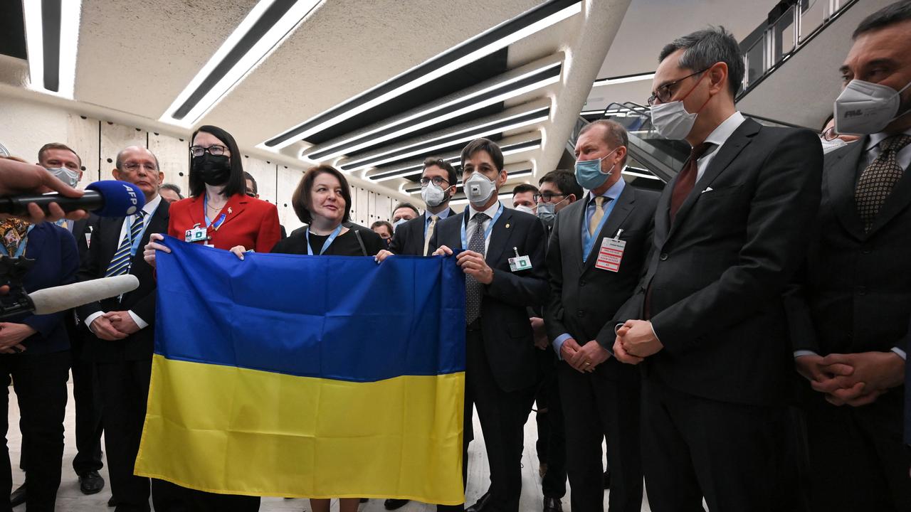 Ambassadors and diplomats gather next to Ukraine's ambassador Yevheniia Filipenko (C) as she holds a Ukrainian flag after the walkout. Picture: Fabrice COFFRINI / AFP