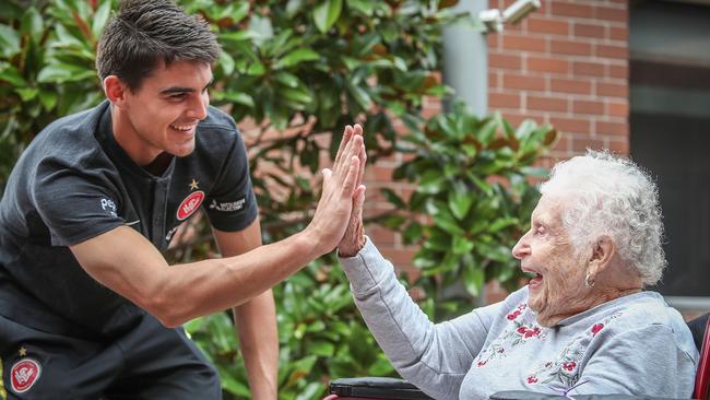 It’s high five time for Wanderers star Marc Tokich and resident Irene Hammond at Bupa home in Bankstown. Picture: Carmela Roche