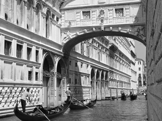 Gondolas pass under the Bridge of Sighs in Venice.