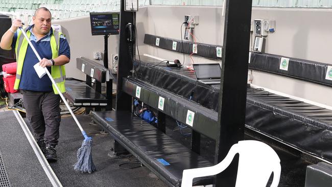 A cleaner mops down the benches before the game. Picture: Michael Klein