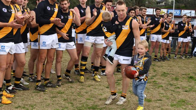 Blair Harvey runs out for his 300th game with sons Brax and Hunter.