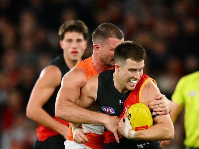 Kieren Briggs of the Giants tackles Zach Merrett of the Bombers: Morgan Hancock