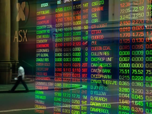 Sydney, Australia - March 5, 2014: An office worker crossing a road is reflected in the glass display of a trading screen at the Australian Stock Exchange on Bridge Street.