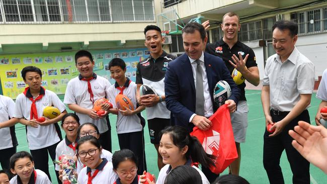 Port Adelaide player Chen Shaoliang, South Australian Premier Steven Marshall and Australian swimmer Kyle Chalmers during a visit to a primary school in Shanghai, China last weekend. Picture: AAP Image/David Mariuz