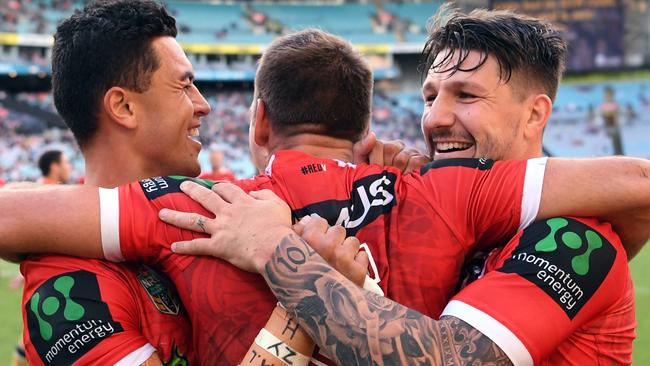 Jason Nightingale (centre) of the Dragons is congratulated by Gareth Widdop (right) and Timoteo Lafai after scoring a try.