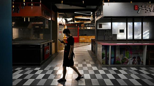 A man walks past closed food stalls at a mall in Beijing . Picture: AFP