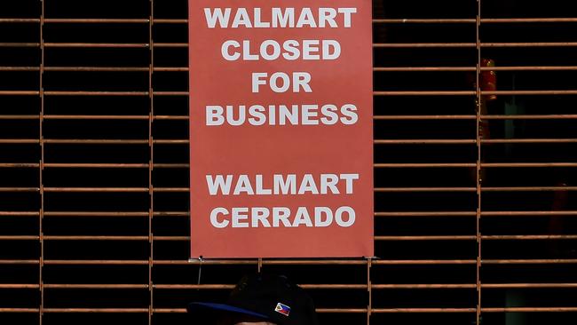 (FILES) This file photo taken on January 28, 2016 shows a closed sign at a Walmart store in Chinatown in Los Angeles, California. Wal-Mart Stores trimmed its sales forecast for fiscal 2017 February 18, 2016 due to store closures and the strong dollar as it reported lower fourth-quarter earnings.The world's biggest retailer saw shares tumble as it reported that it now expects fiscal 2017 sales to be flat, down from the previous outlook for three to four percent growth. Walmart's fiscal 2017 started February 1. / AFP / Mark Ralston