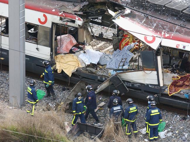 Rescue workers search through the wreckage of a commuter train March 11, 2004 after it was devastated by a bomb blast during the morning rush hour in Madrid, Spain. It killed 191 people and wounded more than 2000. Melbourne terror cell leader Abdul Benbrika was secretly taped discussing launching a similar attack in Australia. Picture; Getty Images