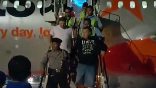 The Australian men are escorted by police off the flight in Bali. (Pic: Supplied)