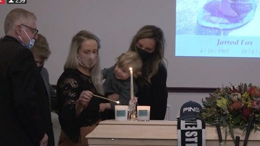 Family members light candles for Jarrod Fox's sons Archer and Jasper at his funeral on August 28. Screenshot from livestream by Belinda Jane Video.