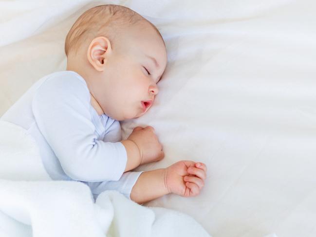 Close-up portrait of adorable baby boy sleeping in bed, 1 year old baby concept