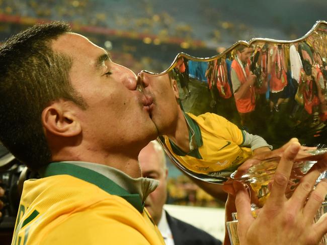 **FILE** A Saturday, January 31, 2015 image reissued Tuesday, July 17, 2018 of Tim Cahill of Australia kisses the Asian Cup trophy after their defeat of Korea Republic between Australia and Korea Republic at Stadium Australia in Sydney. Tim Cahill has called time on his illustrious Socceroos career. Australia's leading international goalscorer confirmed he has retired from international football after scoring 50 goals in 107 caps. (AAP Image/Dean Lewins) NO ARCHIVING