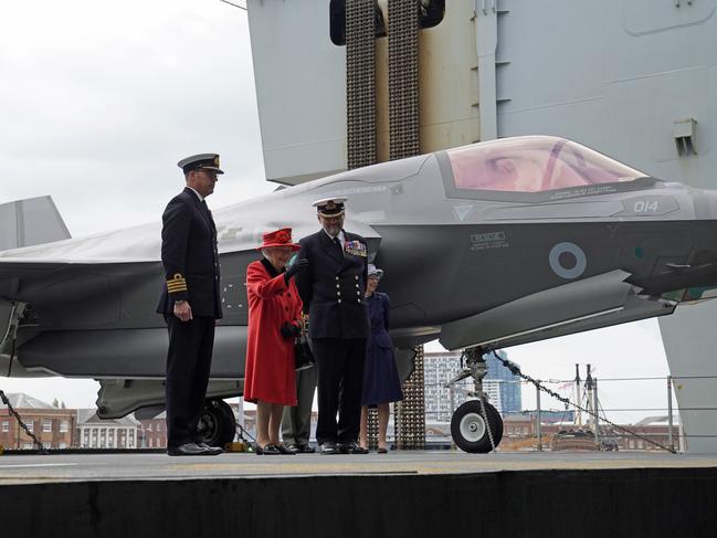 Captain Angus Essenhigh, the Queen and Commodore Steve Moorhouse during a visit to HMS Queen Elizabeth at HM Naval Base ahead of the ship's maiden deployment. Picture: Getty Images