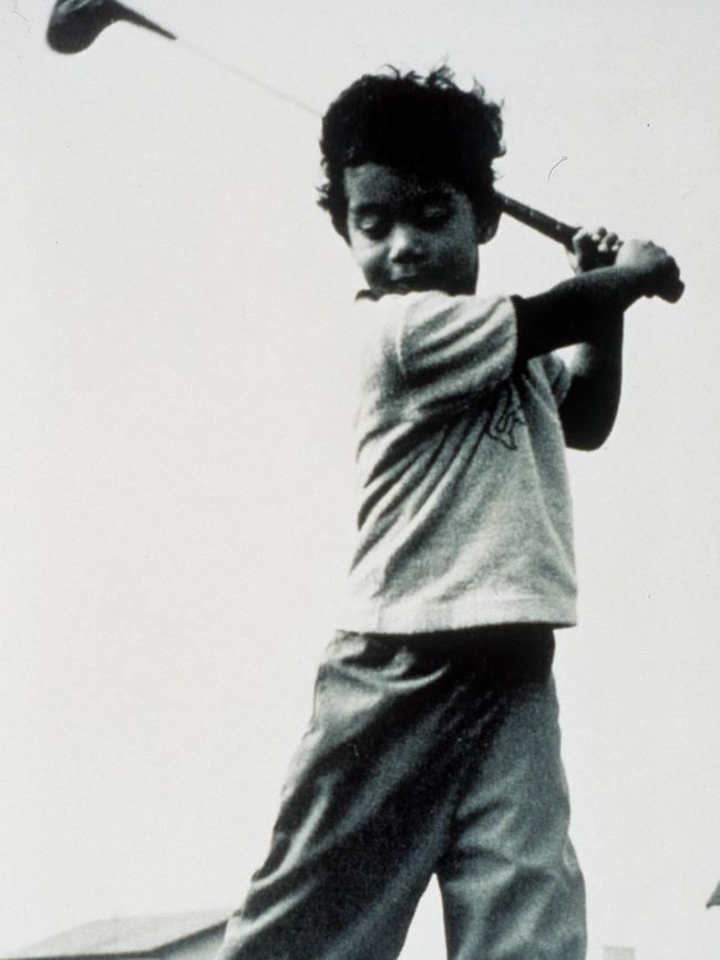 Tiger Woods playing golf as a child. 