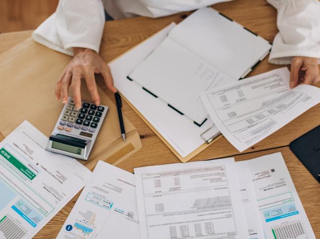 Mature woman at home looking at the bills and taxes and trying to calculate and pay them  - Picture iStock