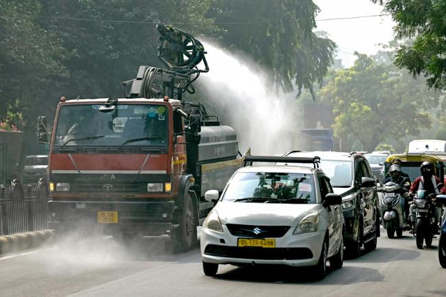 A Public Works Department truck sprays water with an anti-smog gun to curb air pollution in New Delhi