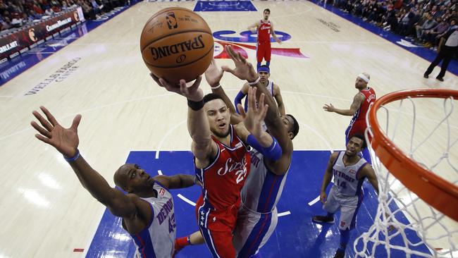 Philadelphia 76ers' Ben Simmons goes up for a shot between Detroit Pistons' Anthony Tolliver, left, and Andre Drummond.