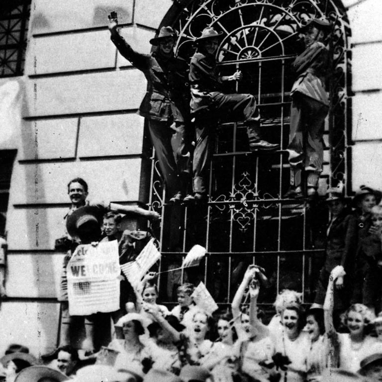 Civilians and Aussie soldiers on December 22, 1941, welcome the first US troops to arrive in Brisbane during World War II.