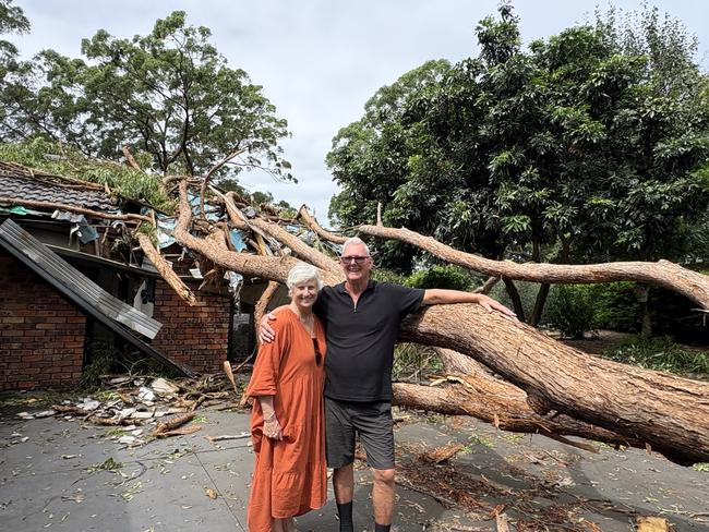 Ian and Sue Hanson with the tree that crashed through their home. Picture: Robert White.