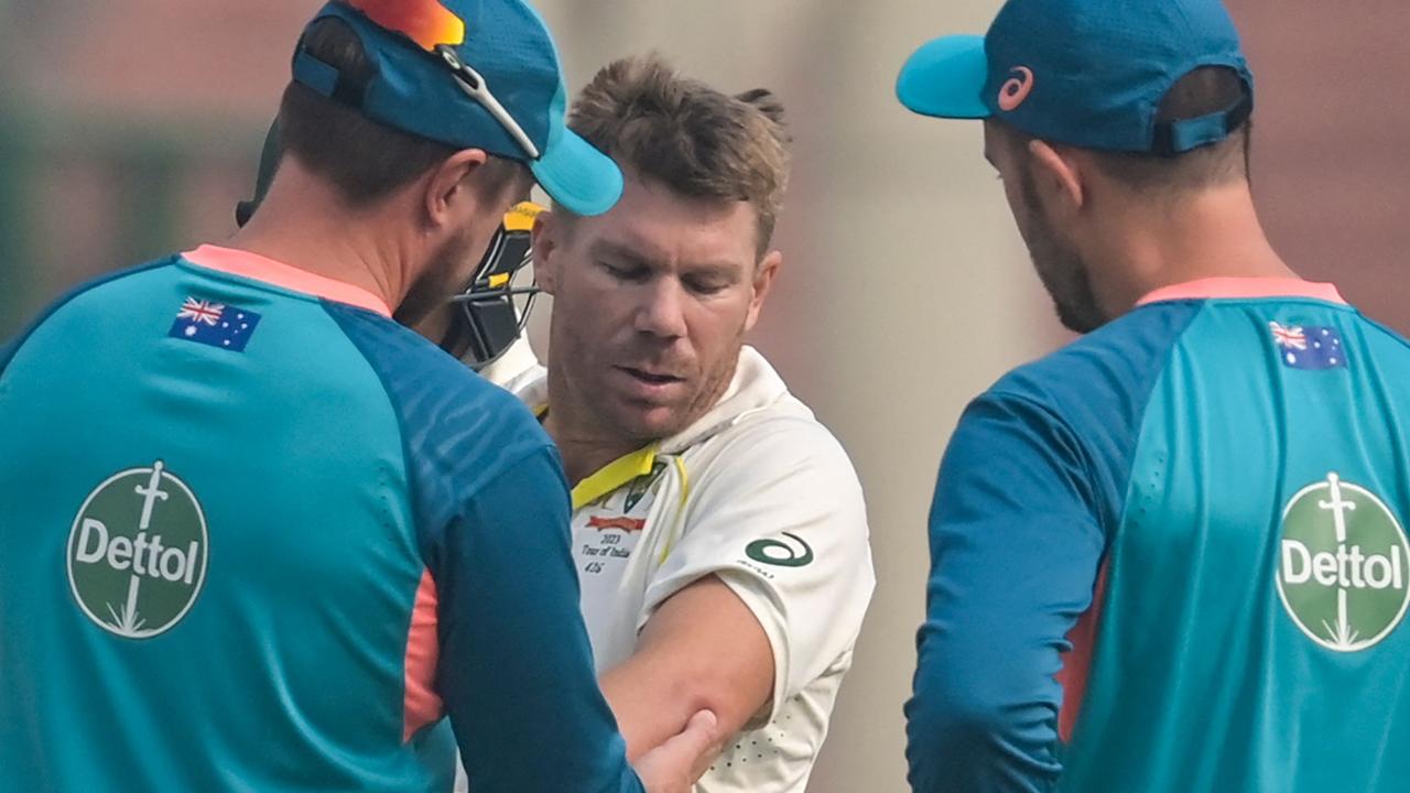 David Warner gets medical aid for his injured arm during the opening day. Picture: AFP