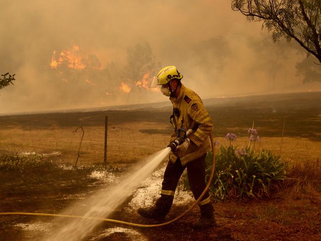 Fire and Rescue NSW firefighters put out spot fires in the Bega Valley, near Wyndham. Picture: Toby Zerna