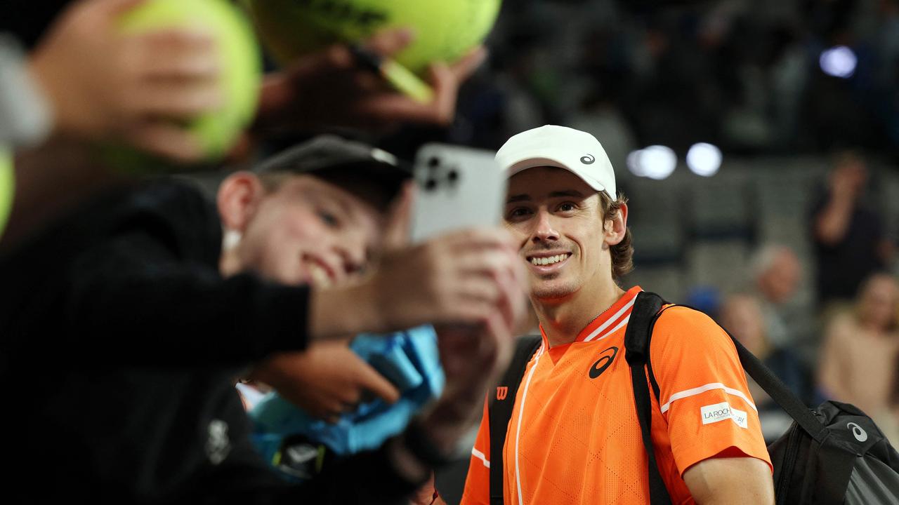 Fans take selfies with Australia's Alex De Minaur after his victory against Italy's Flavio Cobolli during their men's singles match on day six of the Australian Open tennis tournament in Melbourne on January 19, 2024. (Photo by Martin KEEP / AFP) / -- IMAGE RESTRICTED TO EDITORIAL USE - STRICTLY NO COMMERCIAL USE --