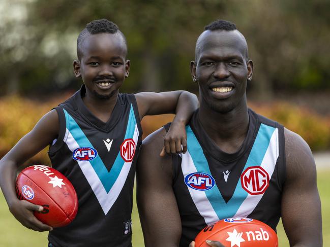 12/09/22 - Port Adelaide footballer Aliir Aliir with his NAB Mini Legend child Timothy Kuol (8). Aaron Francis / Herald Sun