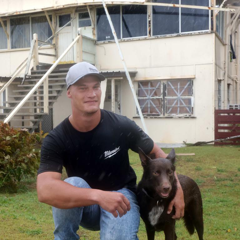 Daniel Goullet with his dog, his house lost part of its roof while he was sleeping when ex-Tropical Cyclone Alfred swept through. Picture: Steve Pohlner