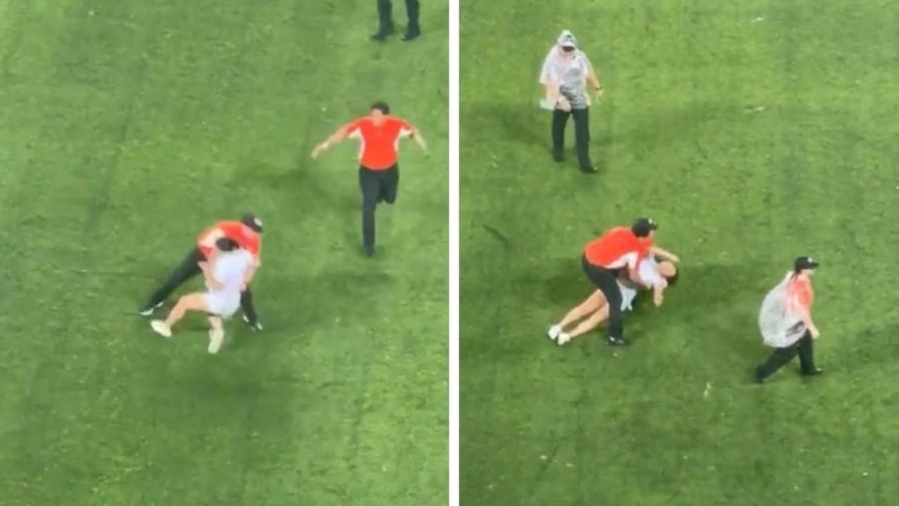 Footage of a female pitch invader getting brutally tackled by security staff at a football game has sparked debate on social media.