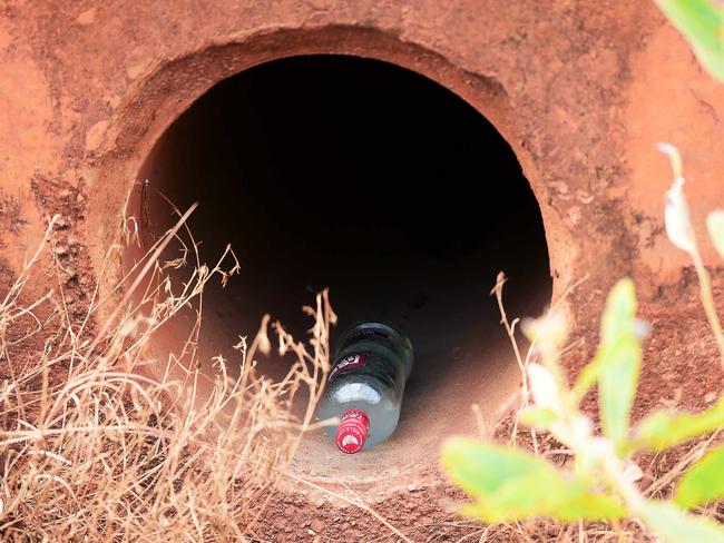 Next to the scene of a fatal car rollover on the Beswick road, police find a bottle of vodka hidden in a culvert. The suspicion is that surviving passengers stashed the bottle following the rollover on Thursday afternoon. Picture: Justin Kennedy