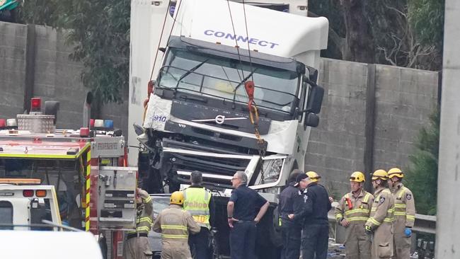 Police have arrested a trucking company employee as part of a sweeping investigation into the horrific Eastern Freeway smash.