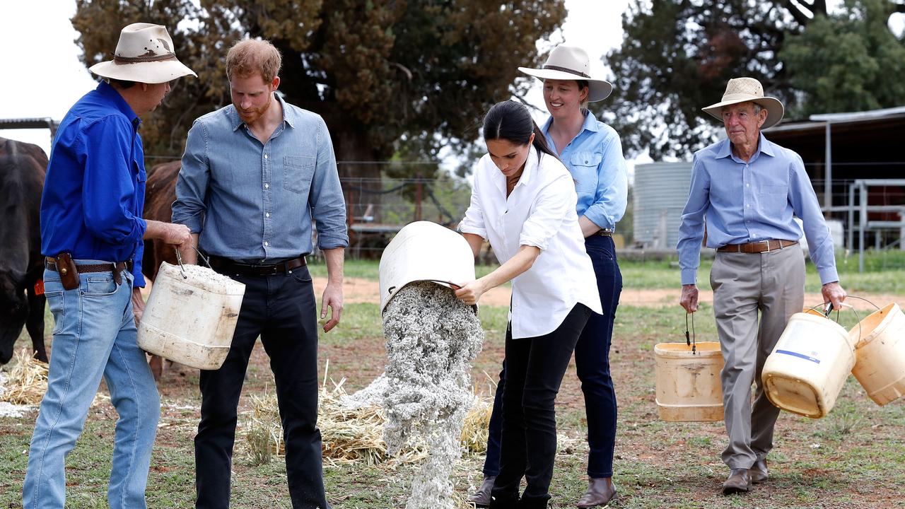 The couple get shown how to feed the stock on the Woodley farm in Dubbo. Picture: Chris Jackson/Getty Images